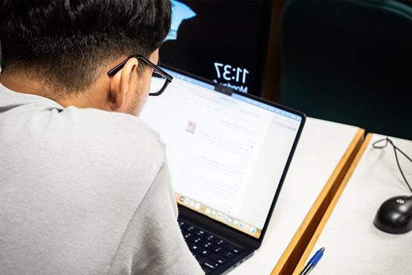 Looking over the shoulder of a student working on a laptop  